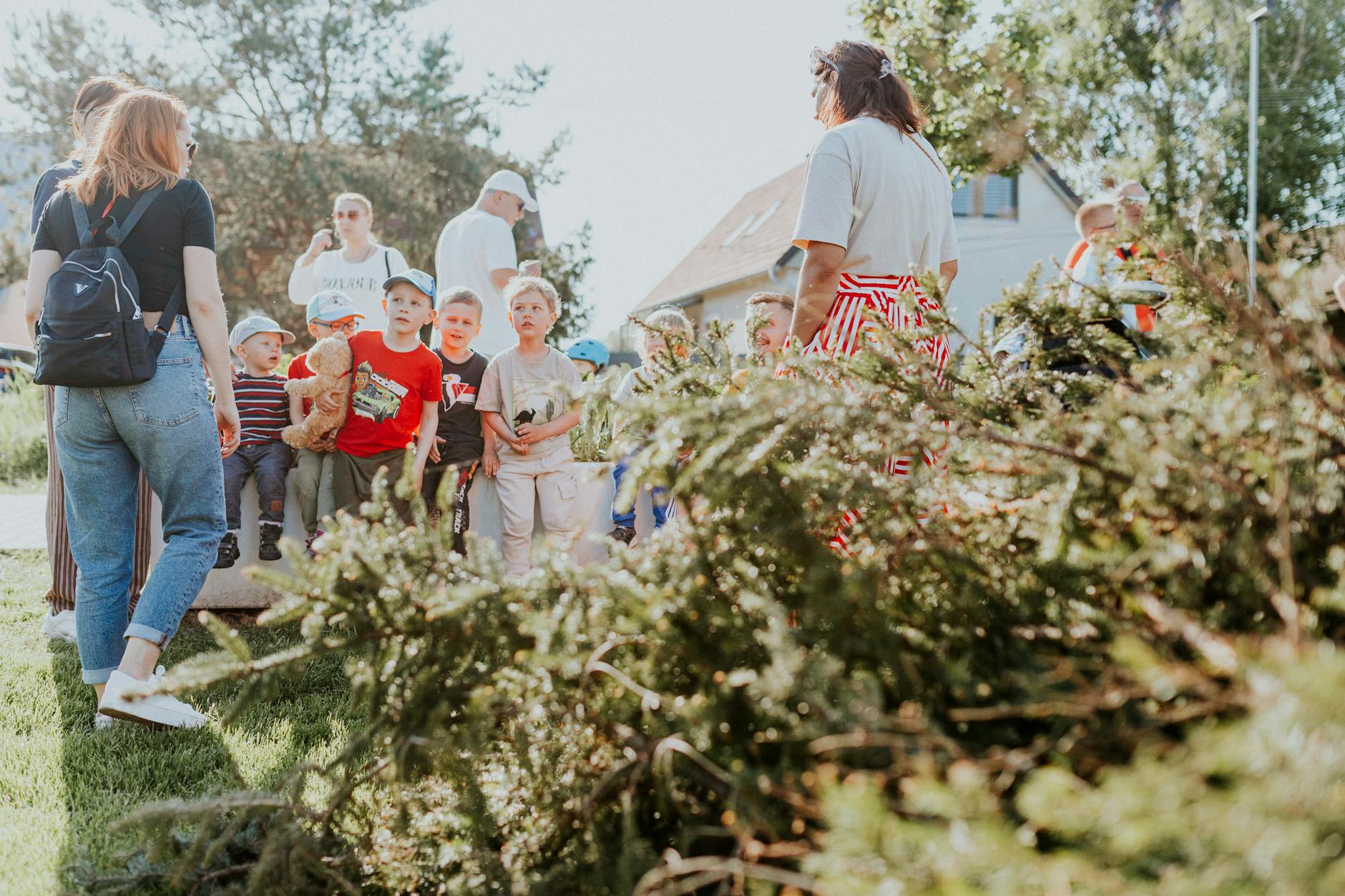 Children and adults participating in an outdoor educational activity surrounded by nature.